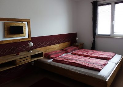 Schlafzimmer mit Doppelbett mit Fernseher