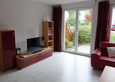 Wohnzimmer mit TV Fernseher Terrassentür